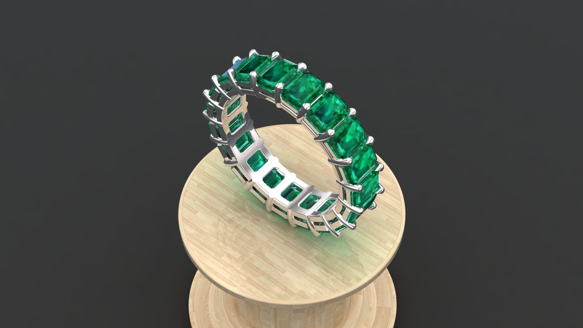 The "Orion" modern wedding band with a full circle of emerald-cut emerald green stones.